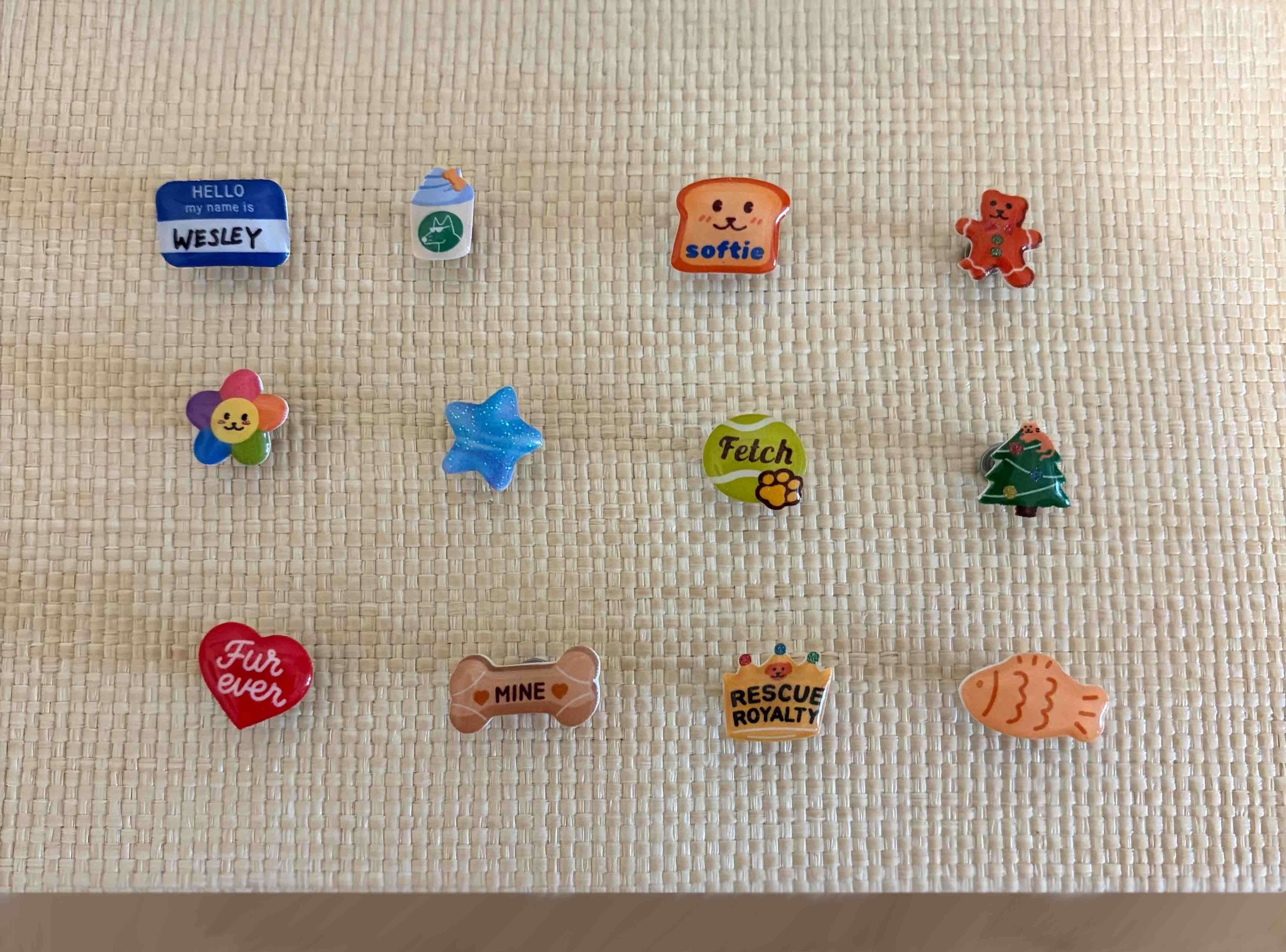 Collection of colorful handcrafted dog collar charms from Pooches & Cream, including heart, bone, star, flower, and bread designs for custom pet accessories.