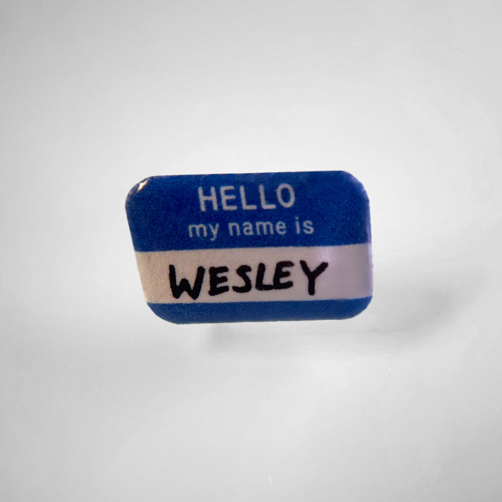 Dog collar charm shaped like a blue name tag sticker.