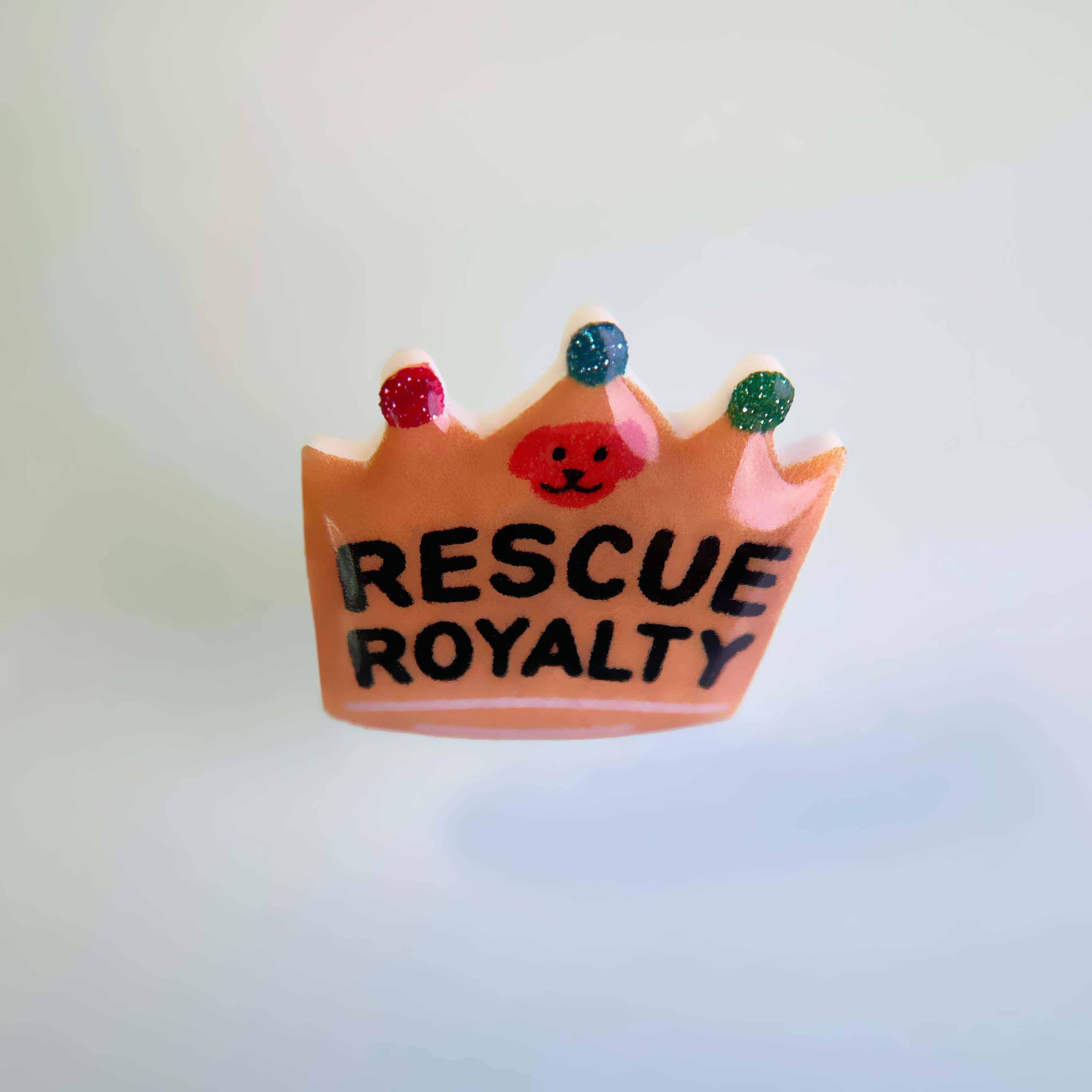 Dog collar charm shaped like a crown with words 'Rescue Royalty'.