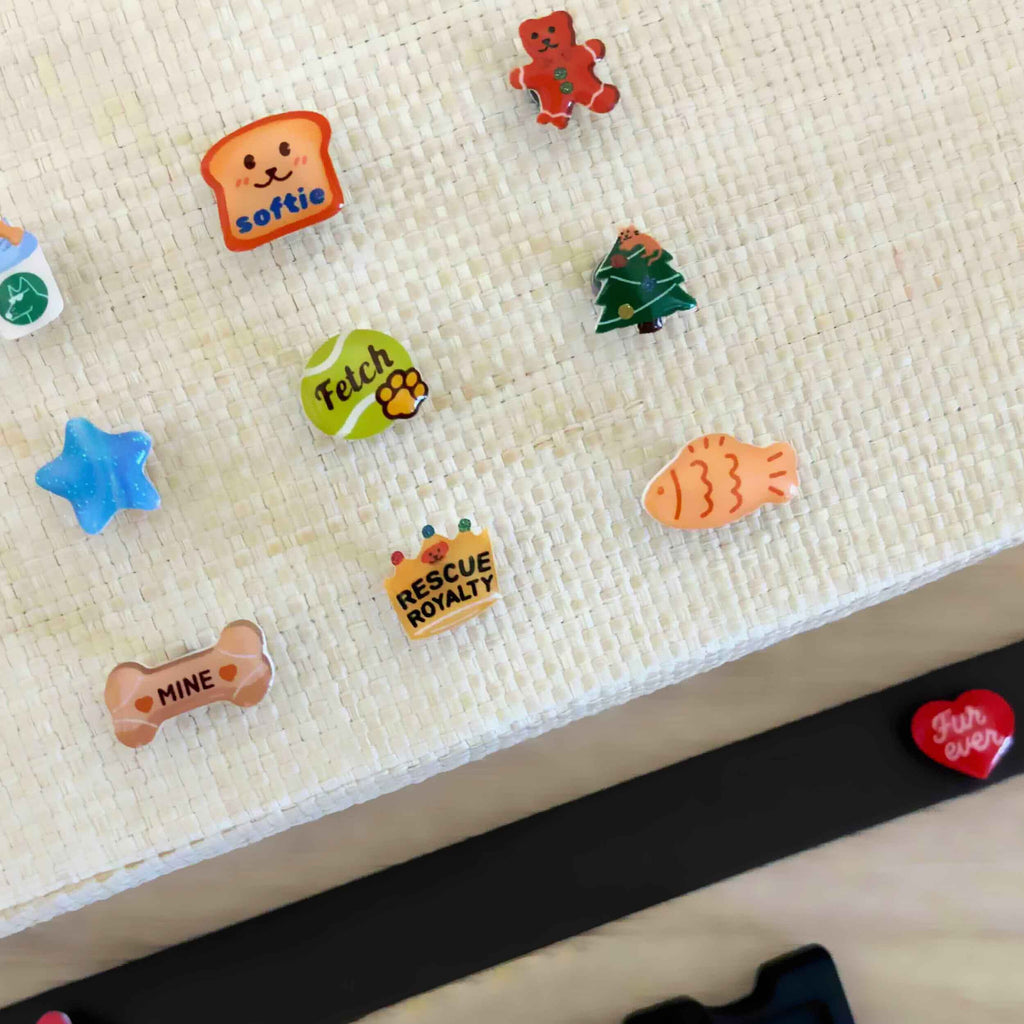 Collection of colorful dog-themed charms on a textured surface