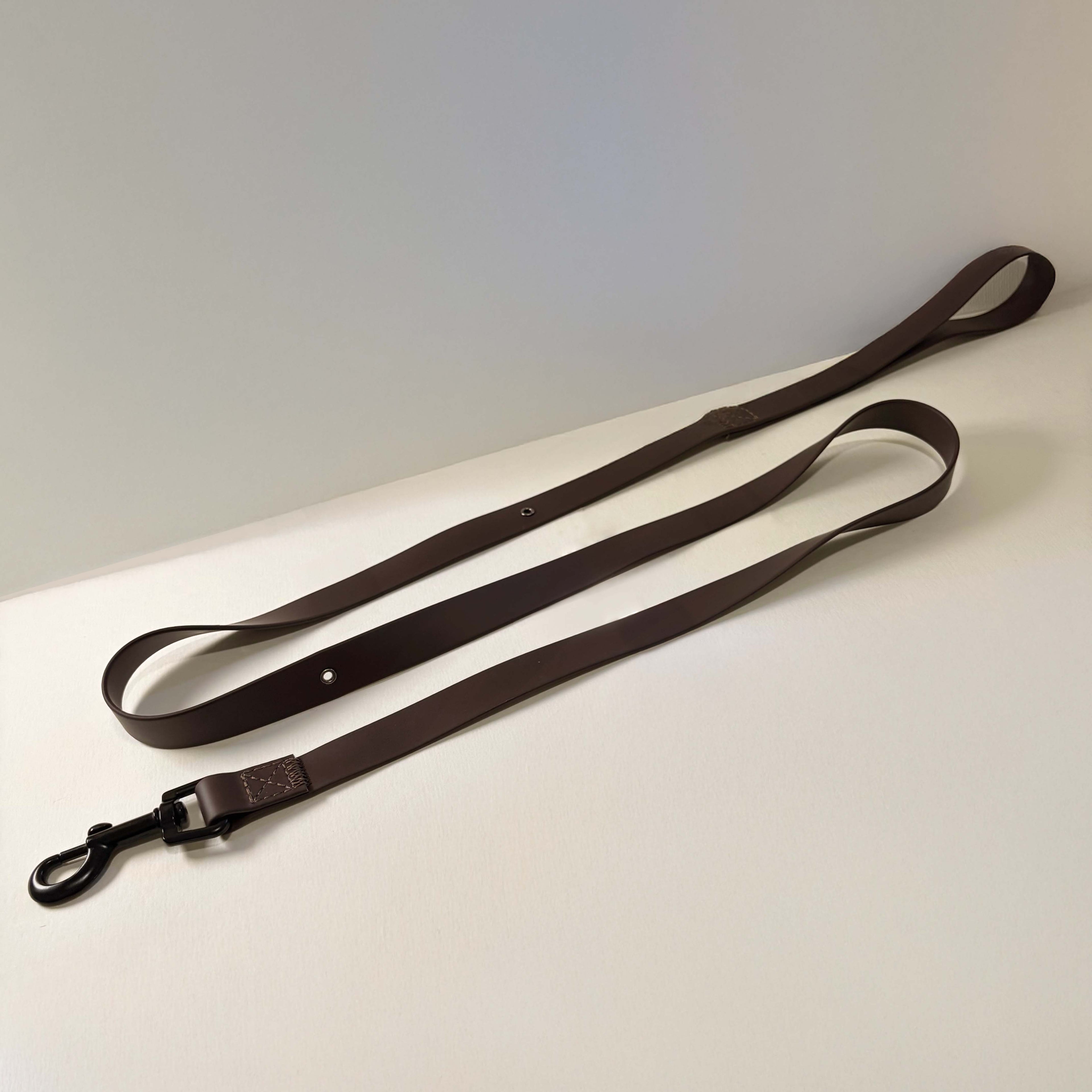 Brown leather dog leash on a light gray surface