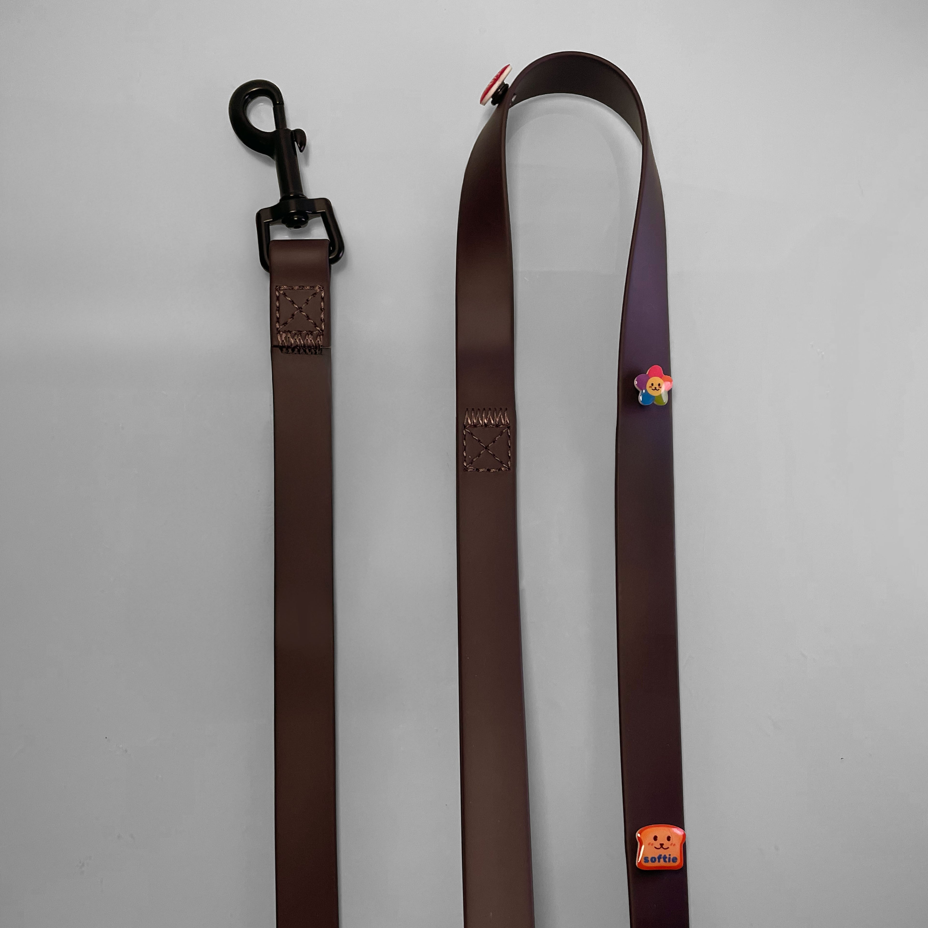 Close up of waterproof brown dog leash showing gunmetal colored hardware detail.